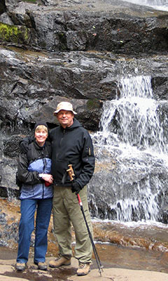 Sue and John hiking by a waterfall